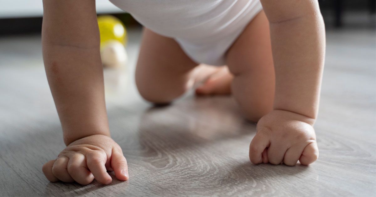 bebé gateando sobre piso vinílico