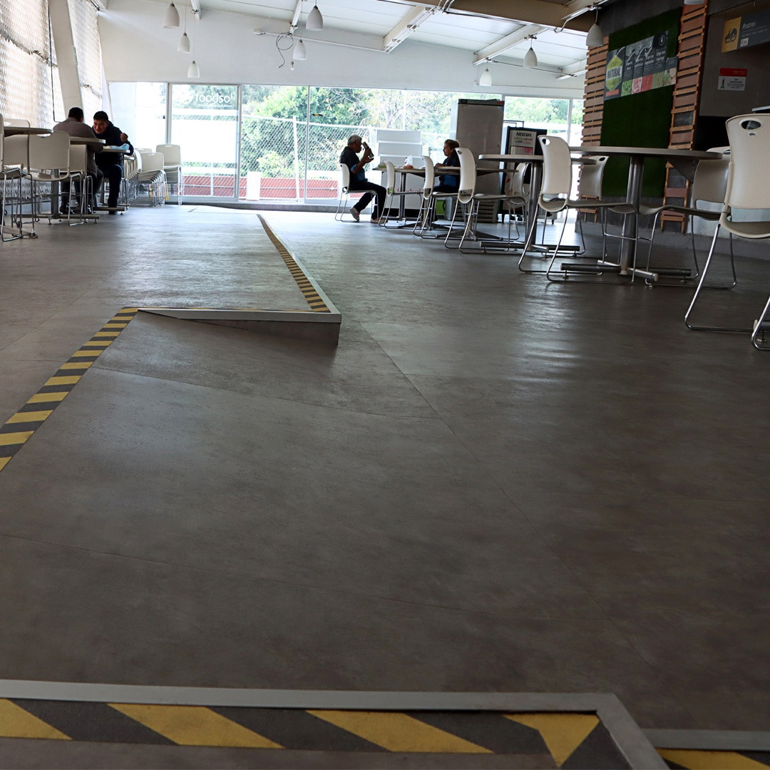 Oficinas de concesionaria con piso vinílico LVT tipo cemento