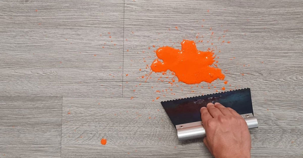 usa una espátula para quitar la pintura seca del piso