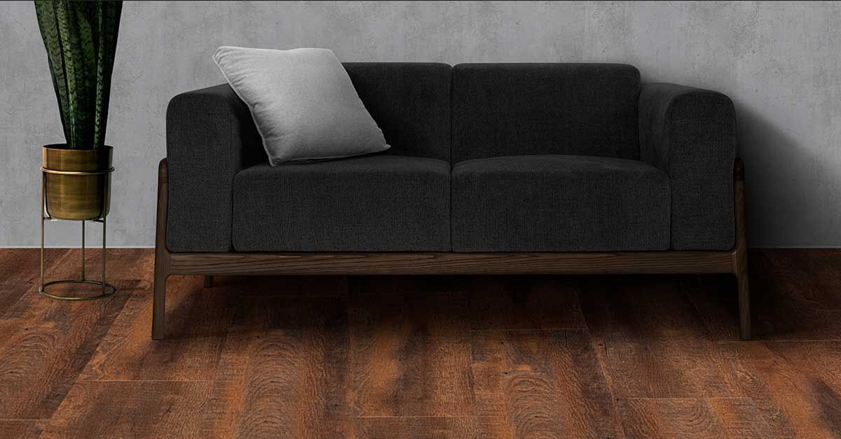 en este fotomontaje se aprecia un sillón gris de estilo mid century sobre piso LVT de lalur en tono vintage que genera un contrasta entre lo moderno y lo clásico