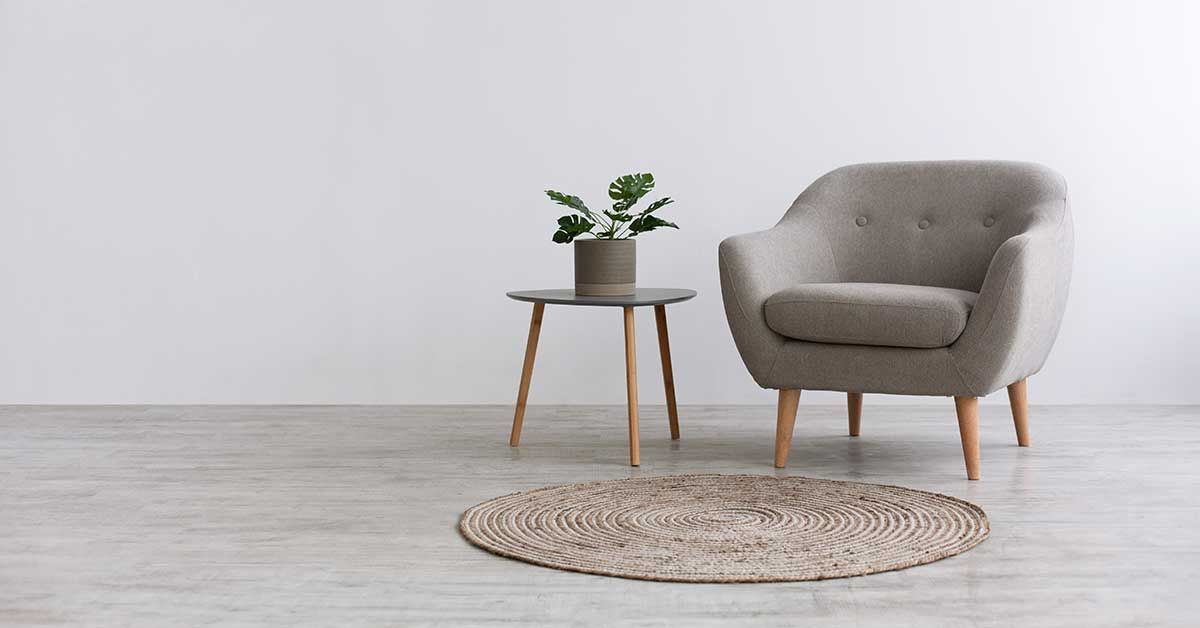 decoración minimalista que consta de un sillón, mesa de centro y un tapete de fibras naturales