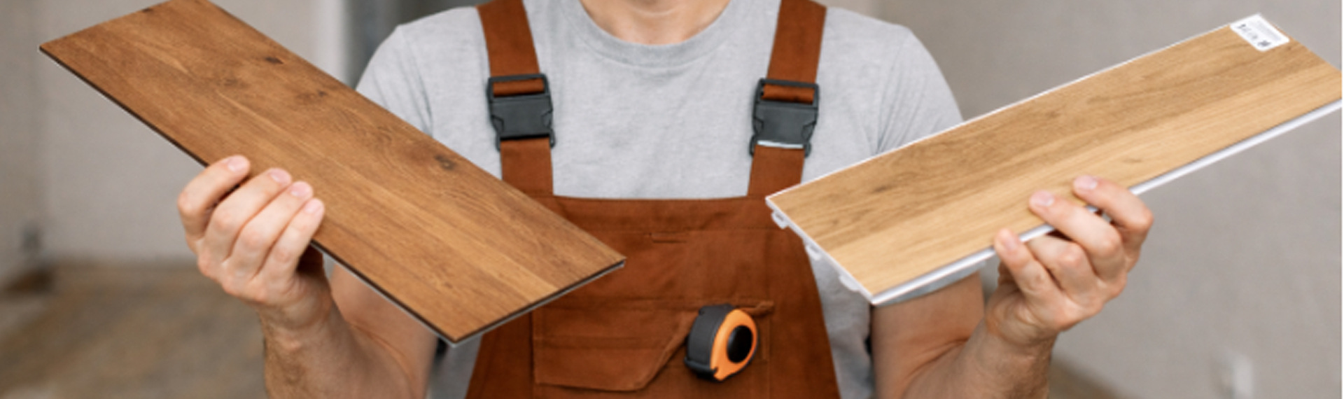 Trabajador indeciso con pisos vinílicos en las manos: SPC en una y LVT en la otra